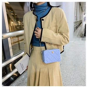 Detail of light blue quilted PVC jelly bag featuring a metal chain strap and sleek mini box design