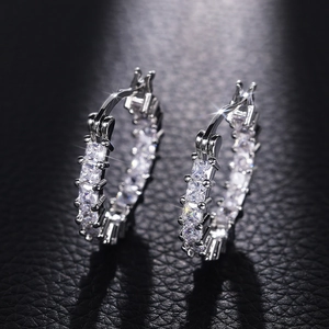 Macro view of silver hoop earrings with square cubic zirconia and secure snap closure