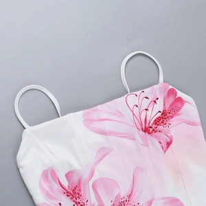 Detail of pink lily print on a white summer camisole with thin straps and U-neckline