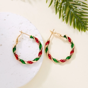 Detail of twisted gold earrings with festive red and green enamel for Christmas