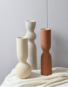 Detail of three Morandi-toned ceramic vases with handmade brushed texture in a minimalist setting