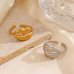 Adjustable lip-shaped rings in gold and silver finish with textured metallic surface