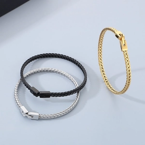 Detailansicht der geflochtenen Drachenknochen-Armbänder in Gold, Silber und Schwarz aus Edelstahl