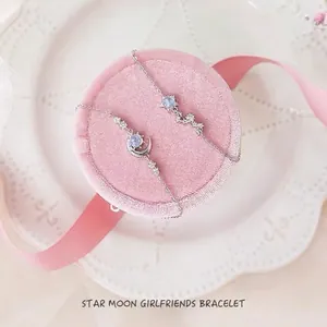 Moon and star bracelet set for women with light blue gems on pink velvet display