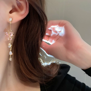 Elegant gold drop earrings with pink butterfly and clear zircon tassels on a model