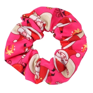 Close-up of pink Christmas hair scrunchie with Santa and gift prints on satin fabric