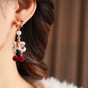 Detail of traditional Chinese lion dance earring with pearls and red velvet ball