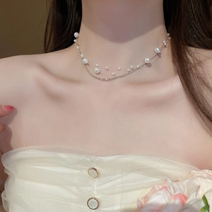 Detailed close-up of double-layer necklace with pearls and sparkling zircon on model neck