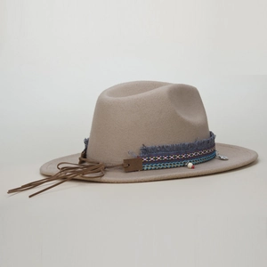 Detail of bohemian khaki fedora hat featuring woven band and stylish long leather tassels