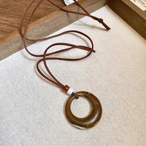 Vintage necklace with amber resin pendant and wooden beads on a dark brown cord