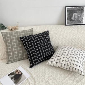 Close-up of minimalist grid pattern cotton linen cushion covers on a cozy white sofa