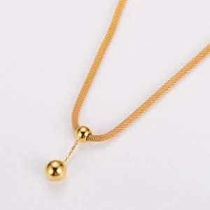 Close-up of golden textured weave chain featuring double spherical tassel pendants