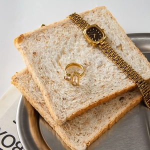 Detailed shot of an 18K gold stainless steel ring with rectangle gemstone and watch