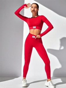 Detail of red high-waisted yoga set featuring seamless knit fabric and GYM WEAR label