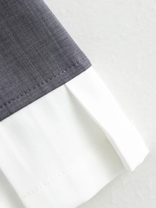 Macro shot of dark grey and white fabric stitching showing high-quality woven texture