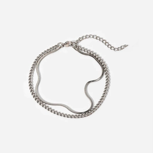 Detail of silver double-layered bracelet with snake and Cuban chain links on white background