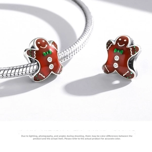 Detailed macro shot of an S925 silver gingerbread man charm with orange enamel finish