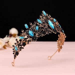 Detail of baroque crown with blue teardrop gems and black rhinestones on gold metal