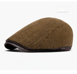 Dettaglio del tessuto tweed kaki a spina di pesce e visiera in pelle marrone
