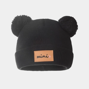 Winter kids black knitted beanie with cute double pompoms and mini leather patch