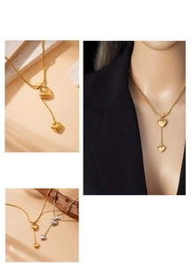 Close-up of double heart pendant necklace with Y-shaped tassel chain in gold and silver finish