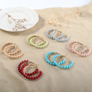 Detailed view of handmade stainless steel hoop earrings with colorful pearl beads