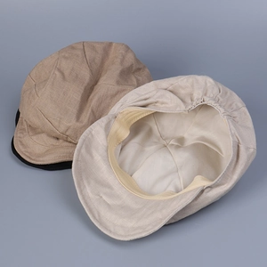 Close-up of linen fabric texture and elastic back on khaki and beige newsboy caps