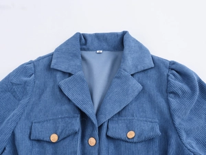 Close-up of blue corduroy dress lapel with gold buttons and chest pocket details