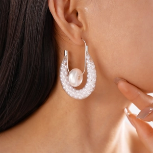 U-shaped mesh tube earrings with white pearls and silver hooks worn by model