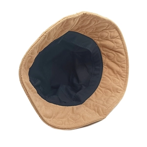 Detailed shot of camel corduroy bucket hat featuring heart-shaped quilted brim stitching