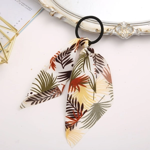 Detail of floral hair scrunchie with tropical leaf print and vintage fashion accessories