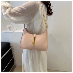 Detail of light pink hobo bag featuring a gold piston lock and chain strap shoulder detail