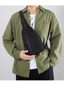 Close-up of minimalist black nylon sling bag with metal zipper worn by male model