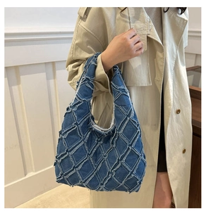 Detail of blue denim patchwork tote bag with frayed edges and diamond pattern