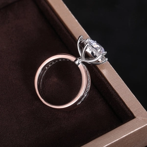 Macro view showing a two-tone engagement ring with a round zircon in a six-prong setting