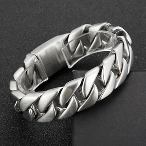 Detailed close-up of heavy Cuban link chain bracelet with matte silver steel finish