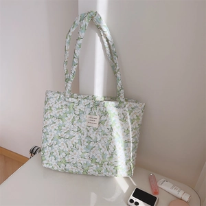 Detailed view of green floral tote bag with fabric patch on padded cotton canvas