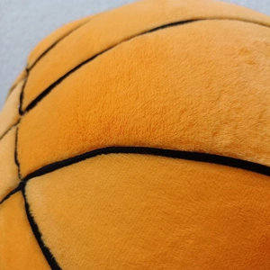 Close-up of the soft plush basketball pillow showing detailed stitching and fabric texture