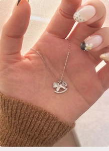 Detail of rocking horse necklace pendant with white mother of pearl and cubic zirconia