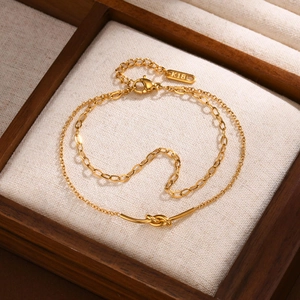Double-layered golden stainless steel chain bracelet with knot design in jewelry box