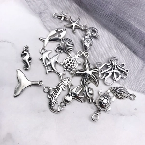Detalle de dijes marinos de plata retro con diseños de caballito, estrella y tortuga
