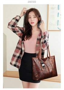 Macro view of large tote bag showing deep brown geometric texture and bear charm