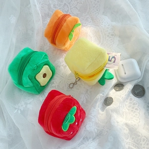 Mini plush fruit-shaped coin purses with zippers and chains on a white lace background