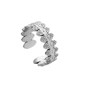 Macro detail of textured silver feather design on an adjustable stainless steel ring