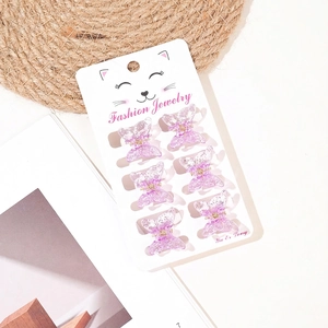 Detailed view of six purple butterfly hair clips with glitter on a display card