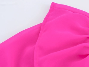 Détail du tissu en mousseline rose vif avec des volants souples et une texture drapée