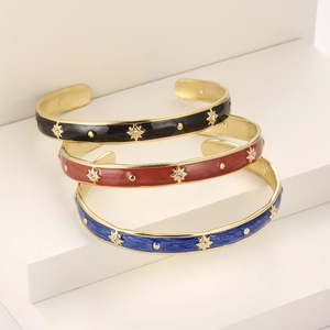 Detailed view of enamel bangles with gold plating and sparkling star patterns
