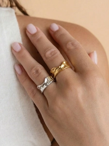 Detail of irregular textured wavy rings in gold and silver finish on model fingers