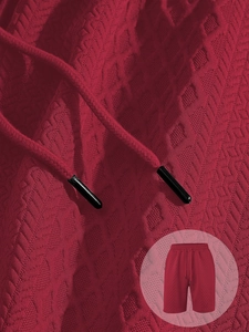 Close-up of red geometric jacquard fabric and black tipped drawstring on men's shorts