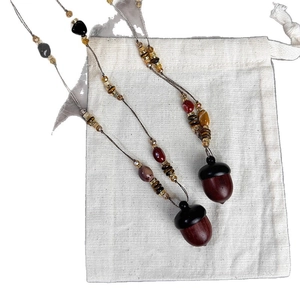Ethnic vintage necklace with hazelnut pendant and assorted stone wooden beads on pouch